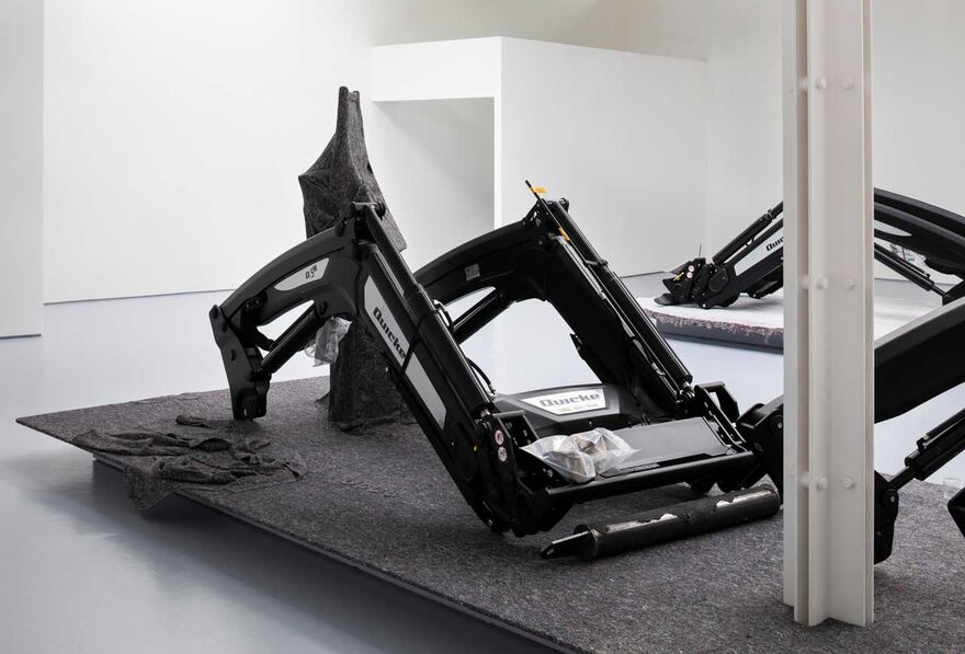 some large farm equipment sitting in a gallery space 