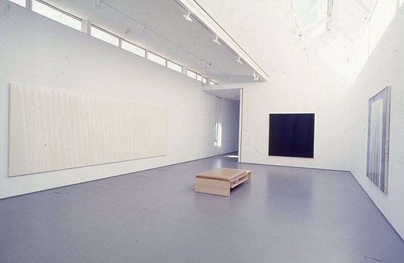DCA Galleries during Ian Davenport's exhibition. A large rectangular white canvas is on one wall, and on the other wall there is a black square canvas.