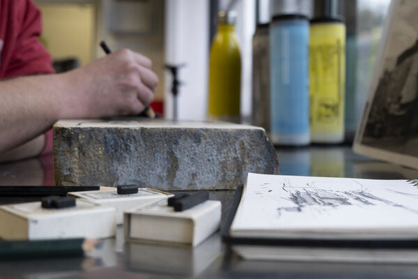 Person drawing on a slab of limestone