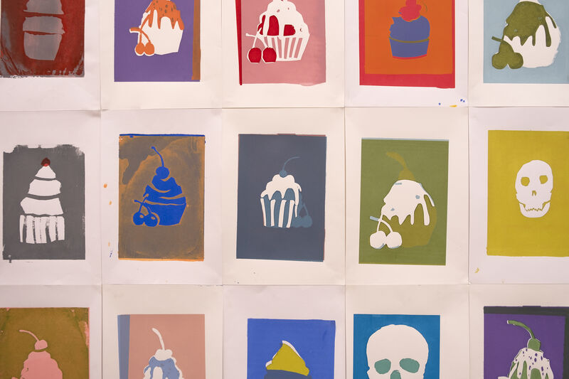 Colourful screenprints of cakes and skulls on the wall of Gallery 1 for Spring Holiday Pop-up