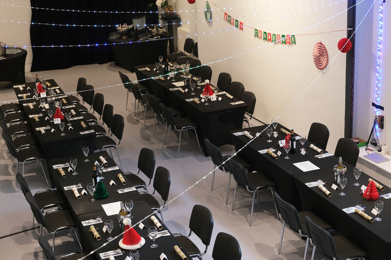 A room set up for a Christmas meal - crackers on the table and wine glasses and wine